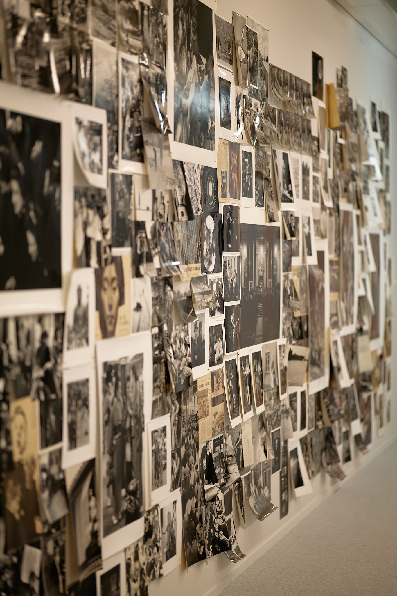 Ett stort antal oramade fotografier monterade på en vägg.