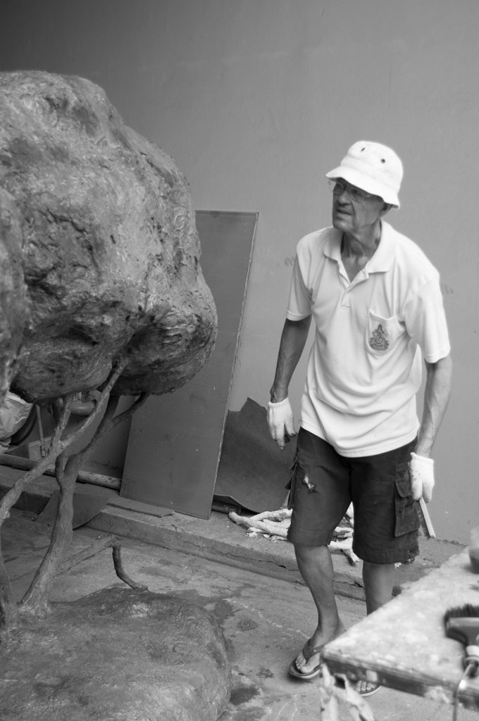 Svartvitt fotografi på Peter Frie framför en skulptur.